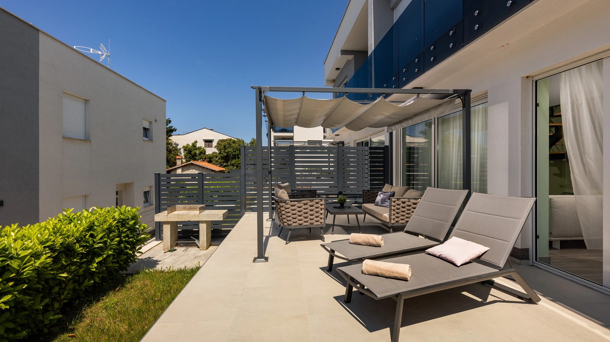 Outdoor terrace beside the apartment building at Three-Bedroom Premium Apartment Near the Sea